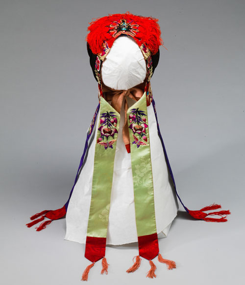 긴 녹색과 붉은 띠가 늘어져있는 붉은 술이 달린 굴레