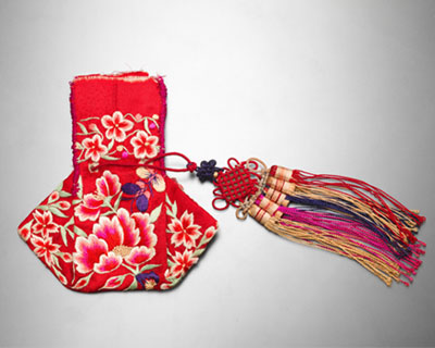 연꽃이 수놓인 붉은 복주머니 끝에 붉고 푸른 색실이 달려있는 사진