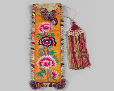 긴 띠에 꽃이 수놓이고 상단에 붉고 노란 술이 끈으로 이어져있는 사진